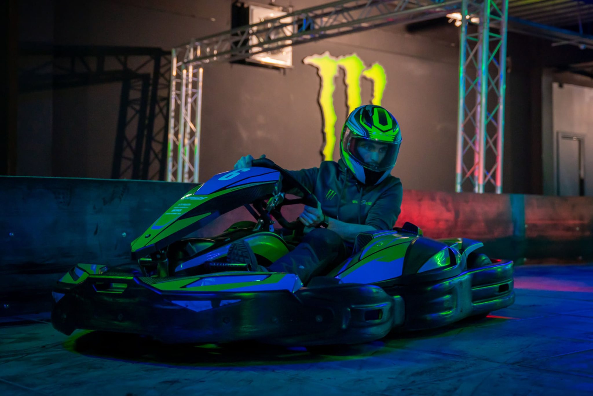 Elevate_Athlone_2560x1707-2048×1366 Person driving a go-kart under colorful lights indoors.