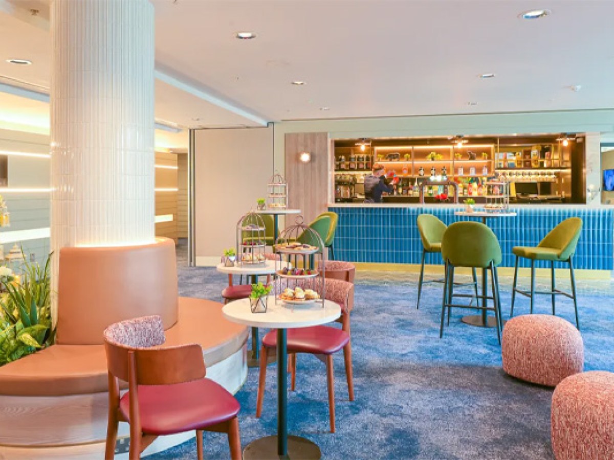 Sheraton Athlone Hotel Siege Suite decorated with seating, tables, and a bar in the background for wedding drinks reception
