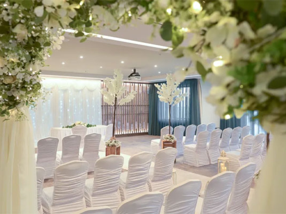 Floral ceremony arch framing an elegant civil ceremony setup at Sheraton Athlone Hotel with white chair covers, blossom trees and romantic wedding décor
