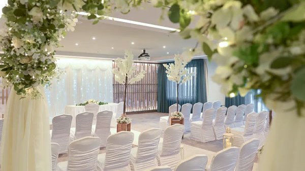 Floral ceremony arch framing an elegant civil ceremony setup at Sheraton Athlone Hotel with white chair covers, blossom trees and romantic wedding décor