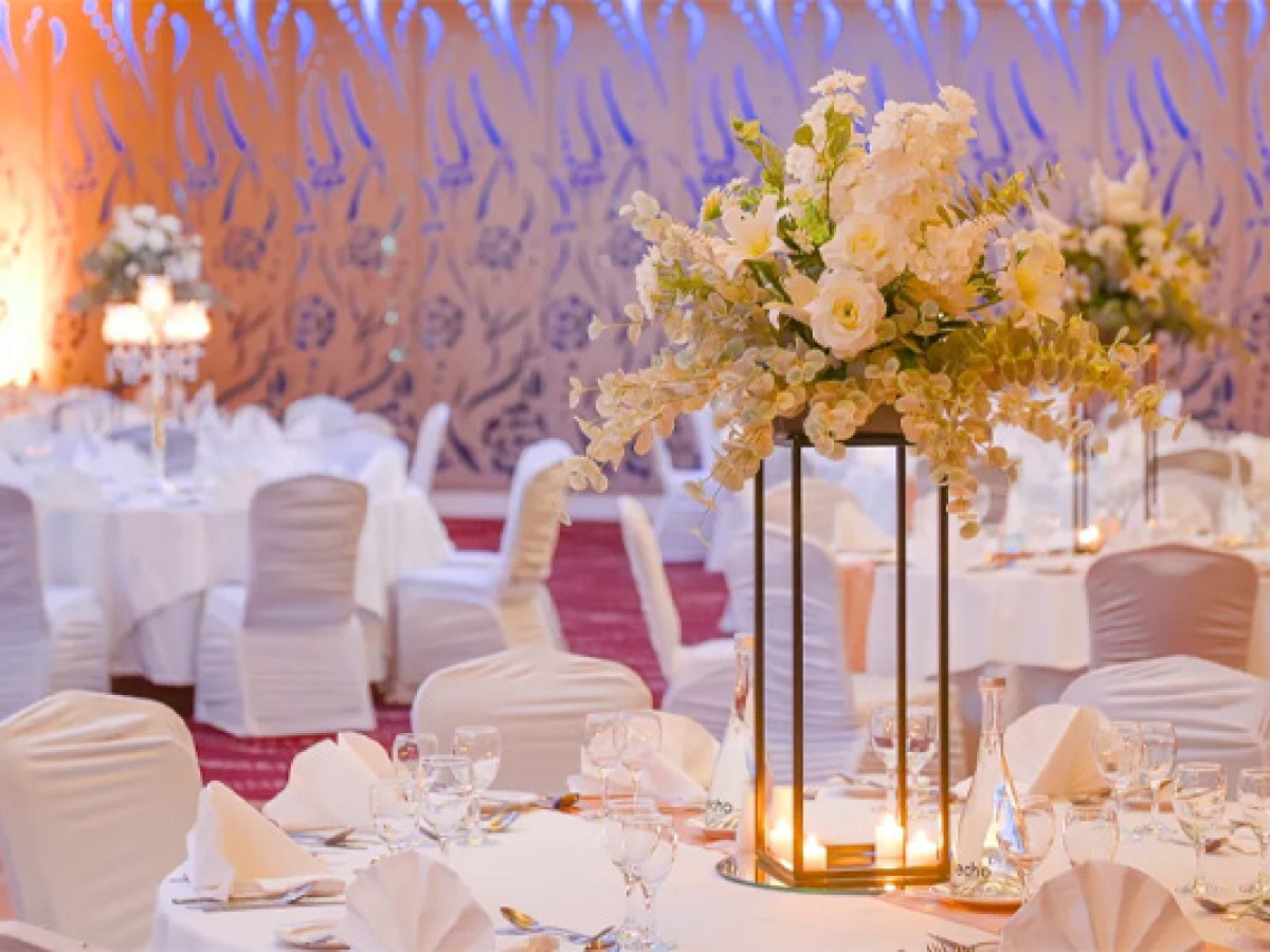 Elegant banquet hall with white table settings and floral centerpiece dur a Sheraton Athlone Hotel wedding